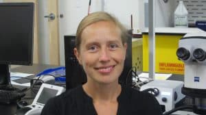 Portrait d'Annabelle Firlej, entomologiste, dans son laboratoire. En arrière plan, un microscope.