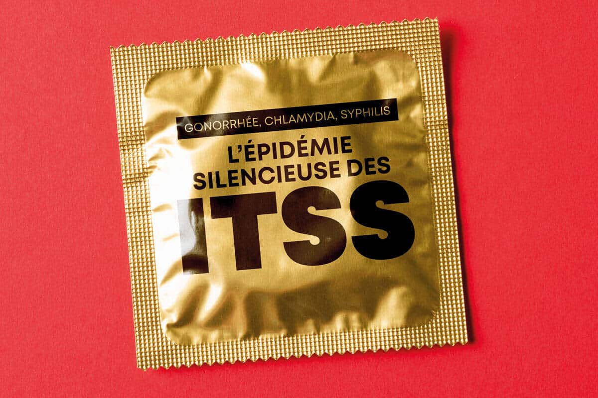 Photo d'un condom emballé. Sur l'emballage, on peut lire "Gonorrhée, chlamydia, syphilis - L'épidémie silencieuse des ITSS"