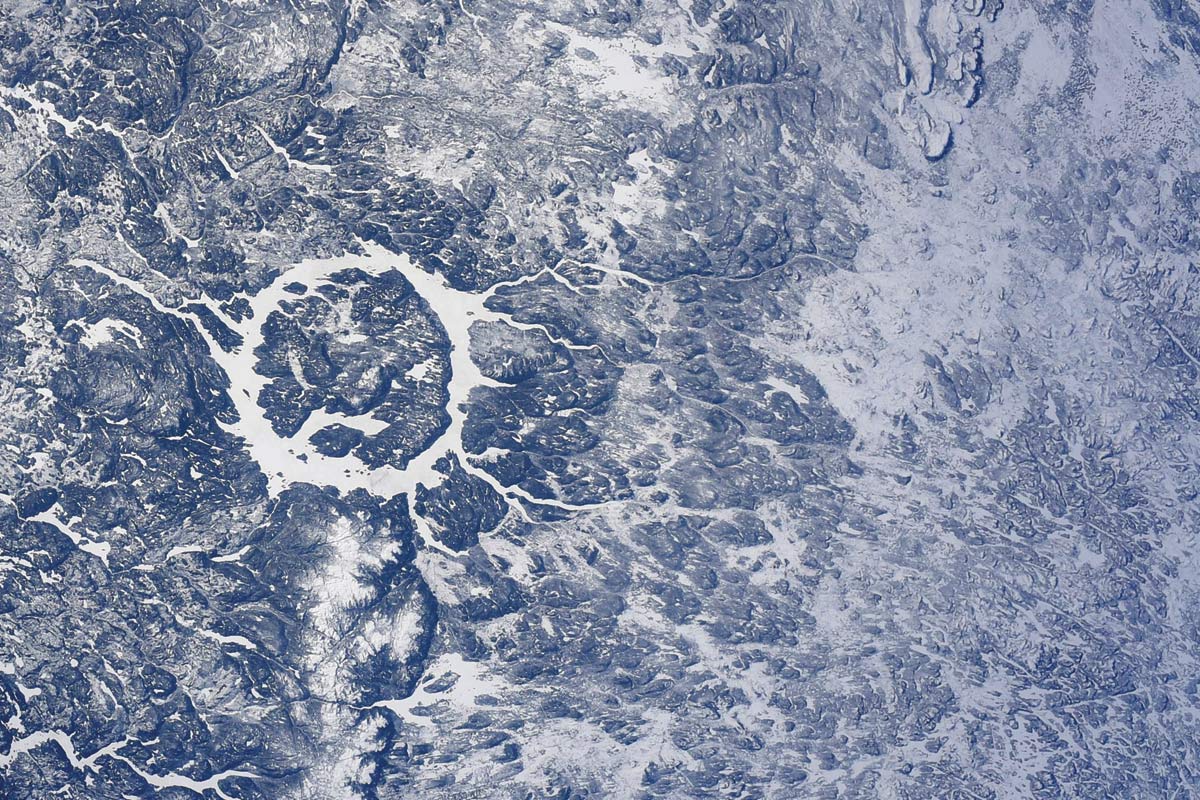 Une texture grise. Dans le tiers gauche de l'image, à mi-hauteur, un anneau blanc aux pourtours inégaux.